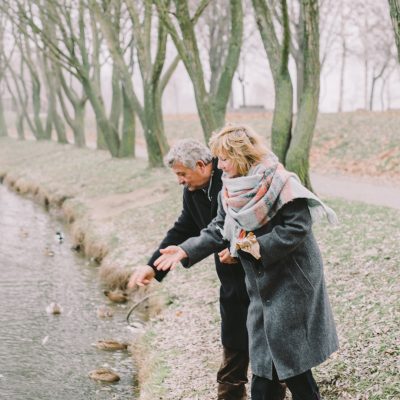 Couple Throwing Treats into a Pond